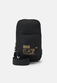 Borsa a tracolla nera in tessuto con logo dorato EA7 Emporio Armani, dotata di una tasca frontale e una tracolla regolabile. Texture liscia, forma rettangolare.