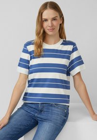 Katoenen T-shirt met horizontale blauwe en witte strepen, ronde halslijn, korte mouwen en een relaxte pasvorm, gecombineerd met blauwe jeans.