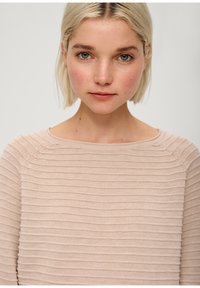 Top a maniche lunghe color beige chiaro, con texture liscia, scollatura ampia e sottili righe orizzontali sulla stoffa.