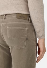 Khaki sztruksowe spodnie o teksturowanym wykończeniu, z tylnymi kieszeniami i skórzaną metką z napisem "BOGGI" w pasie.