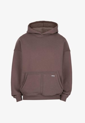 Brauner übergroßer Hoodie mit Kapuze, zwei Fronttaschen, gerippten Bündchen und einem kleinen Metall-Logoschild an der rechten Tasche.