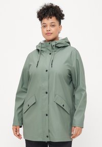 Αδιάβροχο πράσινο μπουφάν με κουκούλα, κλείσιμο με κουμπιά μπροστά και δύο πλευρικές τσέπες. Λείος υφασμάτινος σκελετός με ρυθμιζόμενα κορδόνια.