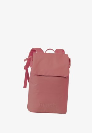 Rosa Nylon-Rucksack mit umklappbarer Klappe, verstellbaren Riemen und einem oberen Griff. Minimalistisches Design mit dezentem Branding auf der Vorderseite.