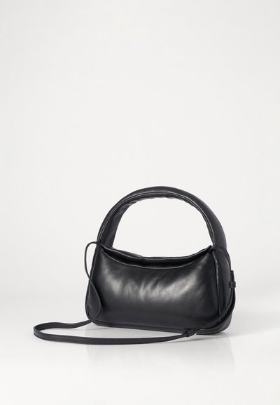 Μαύρη δερμάτινη τσάντα χειρός με καμπύλη λαβή και αποσπώμενο λουρί ώμου. Λείο υλικό, συμπαγές σχήμα και μινιμαλιστικός σχεδιασμός.