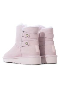 Botines de ante rosa con forro de piel de oveja, que presentan correas laterales dobles y botones metálicos, y una suela de goma texturizada.