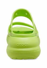 Zielone Crocsy o gładkiej, gumowej fakturze, z dwiema cienkimi tylnymi paskami i zaokrąglonym kształtem, wytłoczone logo na pięcie.