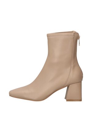 Bota de tobillo de imitación de piel beige con punta afilada, tacón cuadrado y detalle de cremallera lateral para facilitar su uso. Textura suave y diseño minimalista.