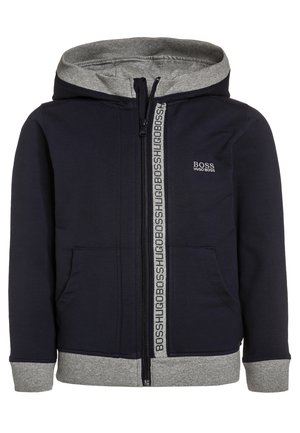 Sweat à capuche bleu marine foncé en tissu doux, avec une doublure de capuche grise, une fermeture zippée à l'avant avec ruban logo, et des poignets et ourlet côtelés.