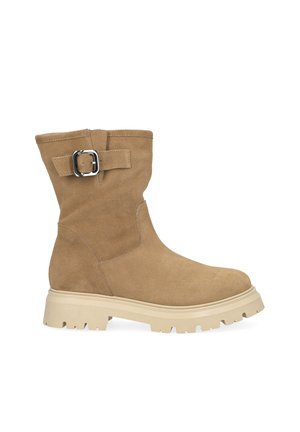 Botte mi-mollet en daim beige avec semelle épaisse beige et bride à boucle argentée sur le côté, vue du côté extérieur.