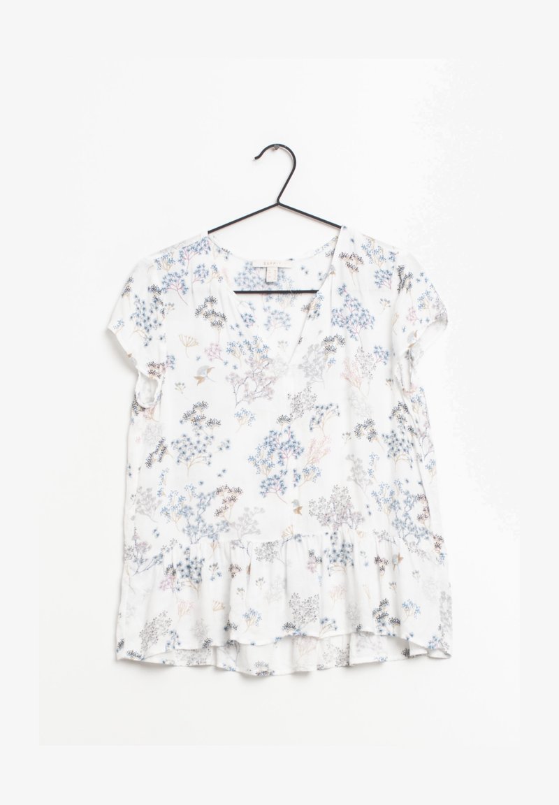Kortærmet, hvid bluse med blomsterprint i sarte blå, pink og grå mønstre. Har en v-hals og en peplumkant. Letvægtsstof.