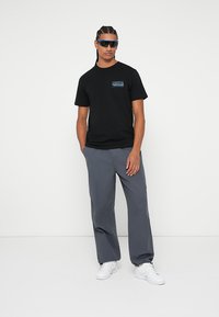 Rip Curl SPORTLINE TEE UNISEX - Potiskana majica - black