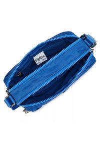 Borsa Kipling blu con doppi cursori, realizzata in materiale morbido. Presenta una sola tracolla regolabile e un'etichetta interna. Texture liscia su tutta la superficie.