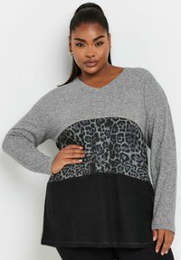 Grauer Pullover mit V-Ausschnitt, der in der Mitte ein schwarzes Leopardenmuster und einen einfarbigen schwarzen Saum hat. Lange Ärmel und weiche Textur.