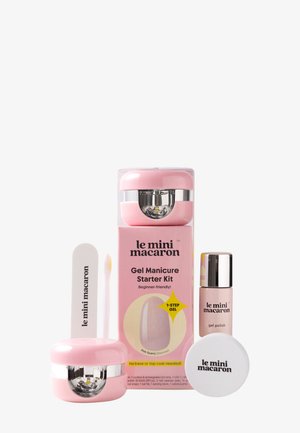 Zestaw startowy do manicure hybrydowego z różową lampą LED, lakierem do paznokci, białym blokiem ściernym, patyczkiem do skórek i opakowaniem oznaczonym "le mini macaron."