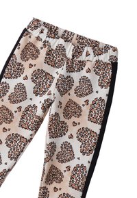 Leggings en imprimé léopard avec des formes de cœur en marron et beige sur un fond clair, présentant un tissu doux et extensible ainsi que des panneaux latéraux noirs.