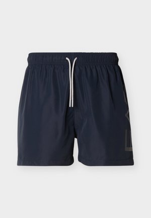 Costume da bagno blu navy realizzato in tessuto leggero, con vita elasticizzata e coulisse, e un elegante dettaglio con logo sul lato.