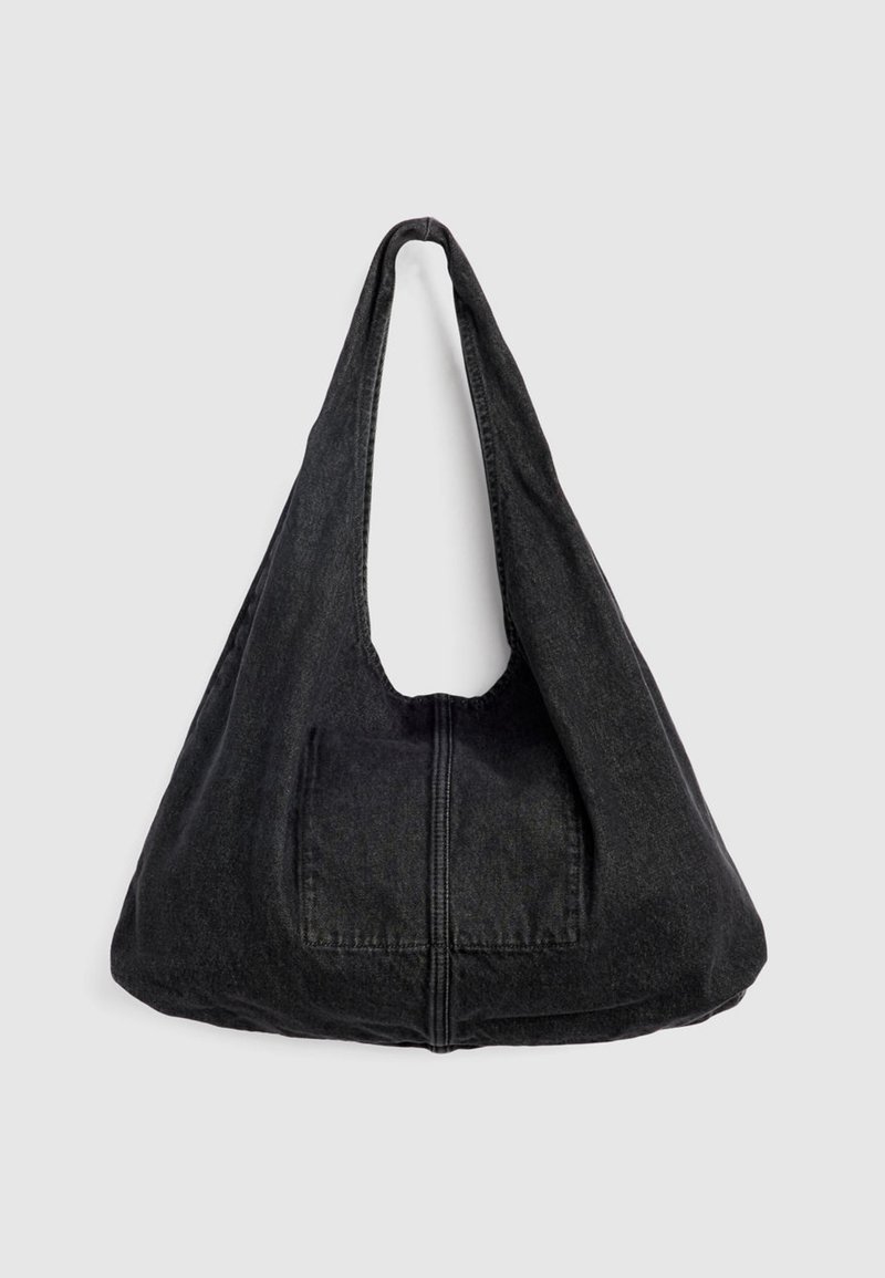 Schwarze Denim-Umhängetasche mit breitem Riemen, vorderer aufgesetzter Tasche und sichtbarer Naht in der Mitte, vor einfachem Hintergrund präsentiert.