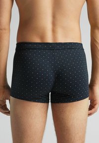 Námořnické modré boxerky s tečkovaným vzorem v světle modré a bílé. Vyrobeny z elastického materiálu, s pružným pasem.