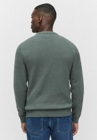 Vihreä neulottu villapaita, jossa on pyöreä kaula-aukko ja ribbireunat hihansuissa ja helmassa. Valmistettu pehmeästä materiaalista, jossa on tasainen pinta ja klassinen leikkaus.