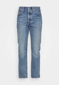 Ljust blå denimjeans med hög midja, rak benform, fem fickor, bälteslinor och knäppning. Blekt utseende med subtila slitningar.