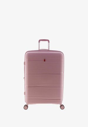 Valigia rigida rosa con texture a righe, manico telescopico in alluminio e quattro ruote nere per la mobilità. Presenta un piccolo dettaglio del logo.