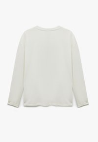 Langærmet trøje med rund hals i off-white, blødt bomuldsmateriale. Har en afslappet pasform og diskret syninger langs kanten og manchetterne.