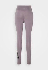 Leggings de sport violets avec une taille haute, en tissu lisse. Présente un petit logo blanc et un accent noir sur la jambe gauche.