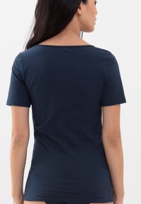 Námořnická modrá trička s krátkým rukávem, vyrobené z měkké tkaniny, vypasovaný střih, s širokým výstřihem a hladkou texturou.