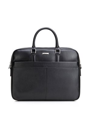 Serviette en cuir noir avec deux poignées, poche avant, plaque de marque argentée et fermeture éclair sur fond blanc.