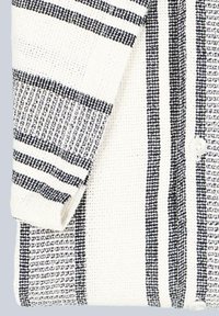 Weißes Hemd mit schwarzen Streifen; strukturierter Strickstoff; verfügt über horizontale und vertikale Musterelemente; umgeschlagene Ärmel.