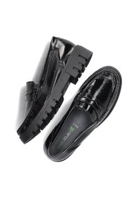 Zwarte lakleren instappers met een chunky rubberen zool en decoratieve stiksel op de bovenkant. Gladde textuur en strakke uitstraling.