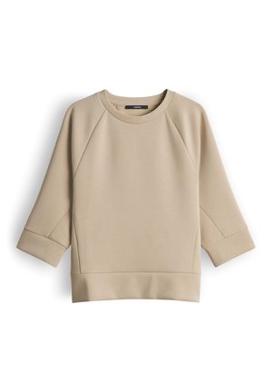 Sweat-shirt beige à col rond avec manches raglan trois-quarts et larges poignets, fabriqué en tissu lisse.
