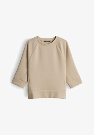 Sweat-shirt beige à col rond avec manches raglan trois-quarts et larges poignets, fabriqué en tissu lisse.