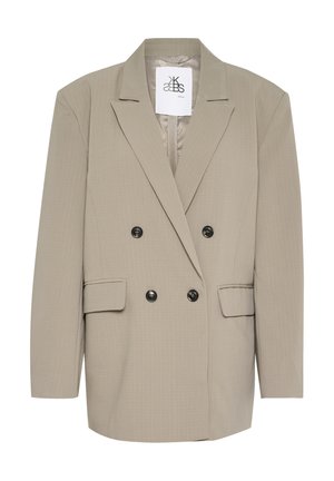 Hellbeige, doppelt knöpfbare Blazerjacke mit scharfen Revers, zwei Vordertaschen und schwarzen Knöpfen. Der Stoff hat ein feines, strukturiertes Muster.