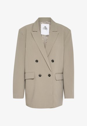 Ljus beige dubbelknäppt kavaj med skarpa slag, två framfickor och svarta knappar. Tyget har ett fint strukturerat mönster.