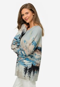 Sweter z prążkowanego materiału z abstrakcyjnym wzorem w odcieniach niebieskiego, beżowego i czarnego; luźny krój z bocznymi rozcięciami i długimi rękawami.