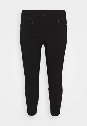 Zwarte broek van rekbare stof. Heeft een aansluitend ontwerp, enkel lengte en twee ritszakken nabij de tailleband.