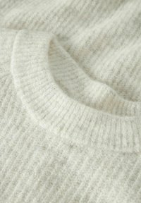 Strickpullover in Off-White mit gerippter Struktur. Verfügt über einen weiten, abgerundeten Ausschnitt und ein weiches, flauschiges Material.