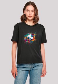 Black cotton t-shirt featuring a colorful graphic of a soccer ball surrounded by vibrant splashes of paint. Relaxed fit and short sleeves.