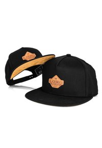 Fekete snapback sapka, strukturált dizájnnal, fekete szövettesttel és barna velúr napellenzővel, melyet egy dombornyomott bőr logóval díszítenek.