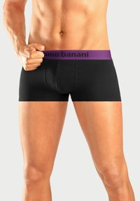 Musta bokserihousut, joissa on violetti elastinen vyötärö, jossa on "bruno banani" -logo. Sileä kangas ja tiukka istuvuus.