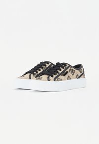 Sneakers in tela beige con motivo floreale nero, lacci neri e suola in gomma bianca. Design low-top e texture liscia.