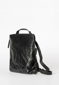 Borsa a tracolla in pelle nera con finitura testurizzata, tracolla regolabile e manico superiore. Presenta una chiusura con zip e un design minimalista.