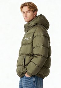 Giubbotto imbottito verde oliva con cappuccio, dotato di zip frontale, cuciture orizzontali e un accento ricamato bianco sul petto.