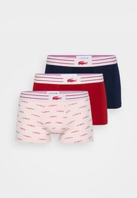 Drie paar herenslipjes: roze met herhaalde logo-afdrukken, effen rood en effen marineblauw. Alle beschikken over een gestreepte elastische tailleband.