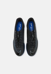 Zwarte sportschoenen met een gestructureerde synthetische bovenkant, blauwe accenten en een slank ontwerp. Inclusief traditioneel vetersysteem en logo-detail.