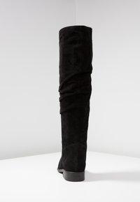 Schwarze Overknee-Stiefel aus weichem Wildleder mit einer legeren Passform, runder Zehenpartie und niedrigem, gestapeltem Absatz.