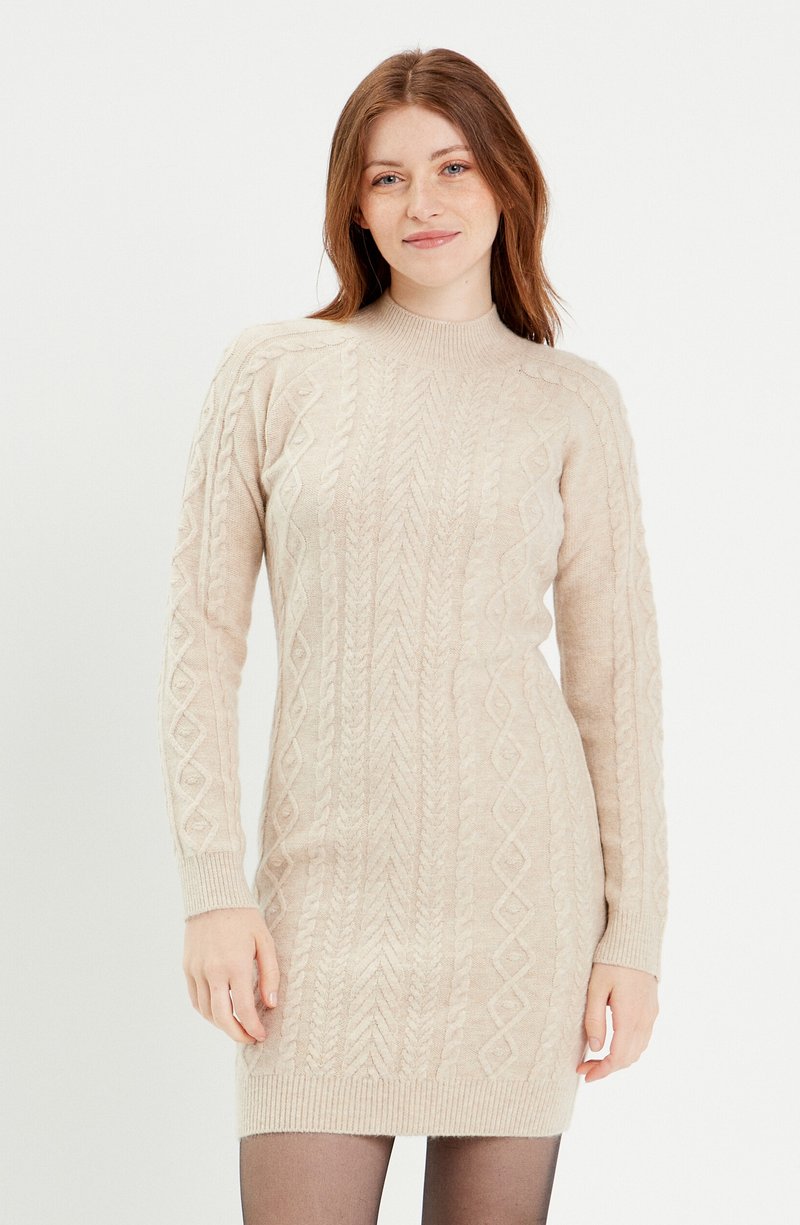 Robe tricotée beige clair avec un col montant, des manches longues et un motif en câbles texturé. Silhouette ajustée, ourlet en côtes texturé.