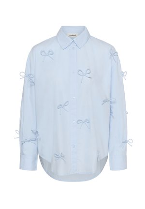 Jasnoniebieska koszula na guziki z długimi rękawami, ozdobiona licznymi małymi materiałowymi kokardkami przyszytymi na przodzie, rękawach i ramionach.