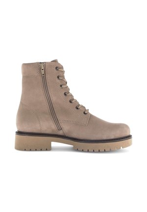 Beige suède enkellaarzen met een vetersluiting aan de voorkant en een rits aan de zijkant, voorzien van een dikke rubberen zool en gestikte details langs de naden.